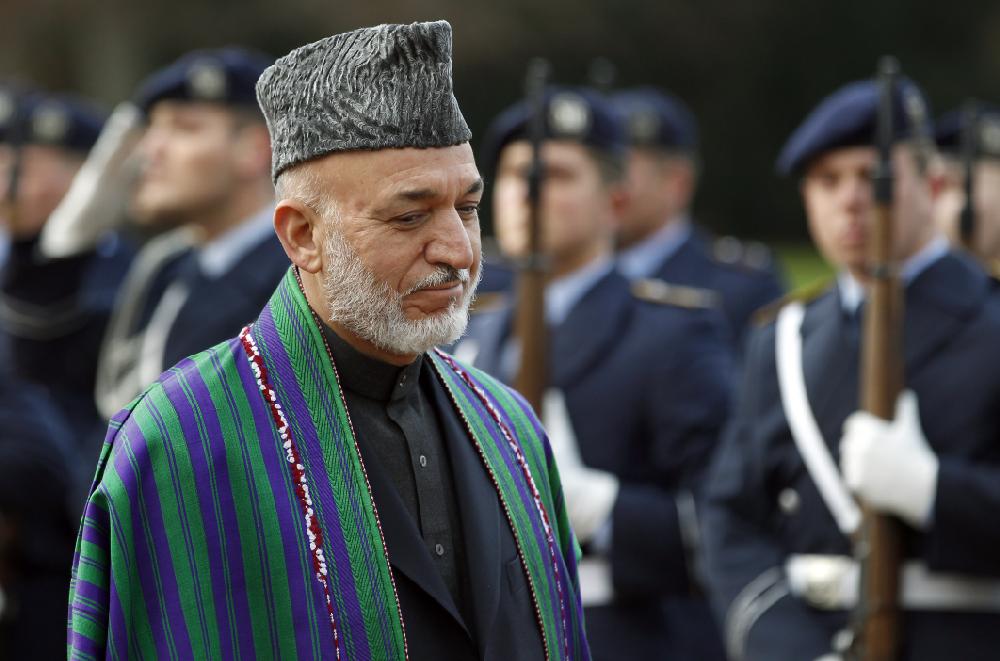 The President of Afghanistan, Hamid Karzai, is pictured in front of German soldiers during a military welcome ceremony at the Bellevue palace in Berlin, Germany, Tuesday, Dec. 6, 2011. (AP Photo/Michael Sohn)