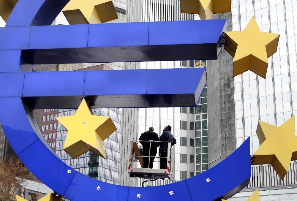 Workers change tube lights of the Euro sculpture in front of the European Central Bank in Frankfurt, Germany, Tuesday, Dec.6, 2011. (AP Photo/Michael Probst)