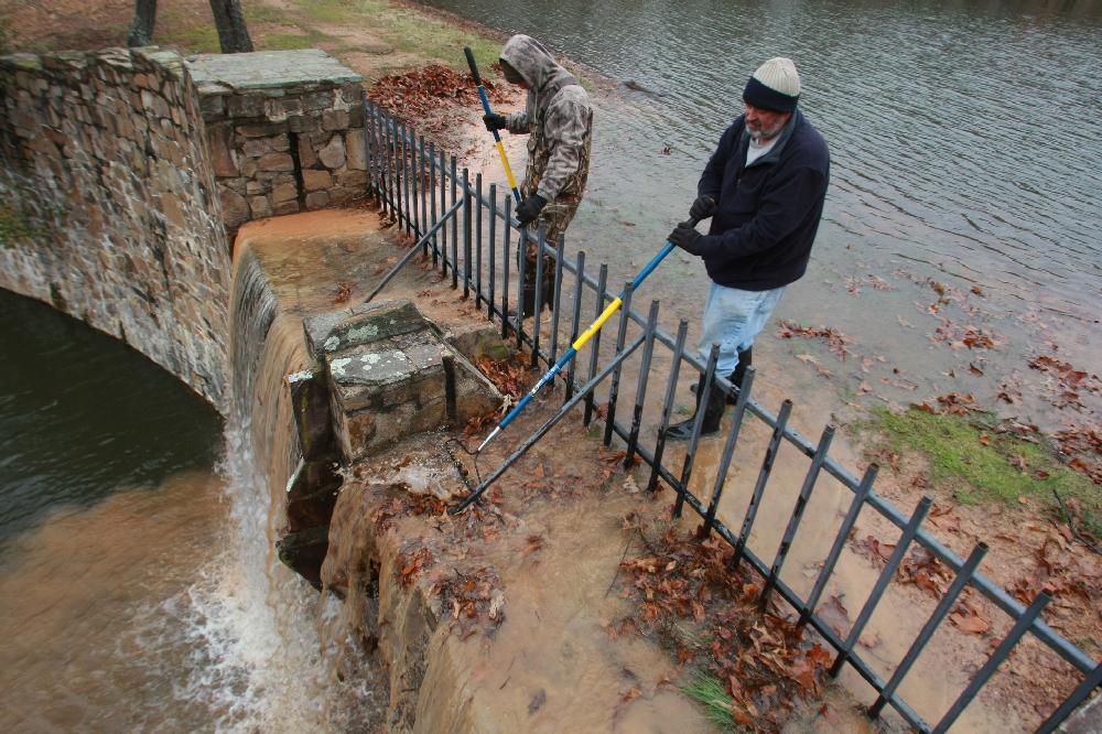 Arkansas Democrat-Gazette/RICK MCFARLAND --12/06/11-- Phillip Oswald (left) and Chris Blake, with the Lakewood Property Association, clean leaves away from the fence between Lakewood Lakes No: 4 (left) and No: 5, in North Little Rock Tuesday.