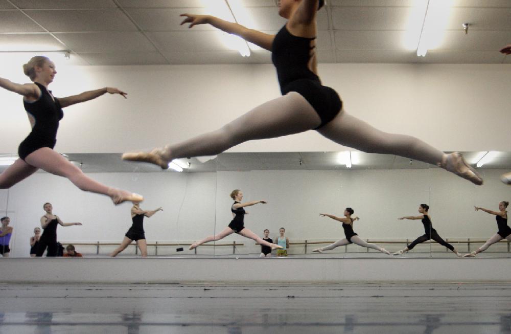 11/20/11
Arkansas Democrat-Gazette/STEPHEN B. THORNTON
Kathryn Latham, 14,  left, and Lauren-Frances Wood, 12, (both bottom center) watch from the sidelines as a large group of performers leap through the air as they rehearse  Ballet Arkansas' The Nutcracker Sunday afternoon at Shuffles & Ballet II in Little Rock. The girls will alternate playing the role of Clara in the ballet.