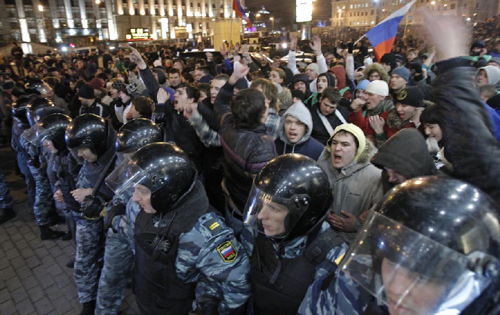 Police protect members of pro-Kremlin youth movements gathered at Triumphal Square in Moscow, Russia, Tuesday, Dec. 6, 2011. Police clashed with demonstrators protesting alleged election fraud in Moscow and at least two other major Russian cities on Tuesday as anger boiled against strongman Prime Minister Vladimir Putin and his ruling United Russia party. Pro-Kremlin supporters also put on a pair of large rallies in Moscow, attracting thousands and showing vehement divisions in Russian society. (AP Photo/Ivan Sekretarev)