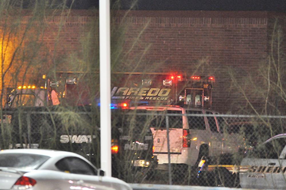 A rescue unit of the Laredo Fire Department is stationed at a side entrance to the Texas Health and Human Services Offices Monday, Dec. 5, 2011. A Texas woman who for months was unable to qualify for food stamps pulled a gun in a state welfare office and staged a seven-hour standoff with police that ended with her shooting her two children before killing herself, officials said Tuesday. Authorities identified the mother as Rachelle Grimmer, 38, and children Ramie and Timothy. Laredo police investigator Joe Baeza said Grimmer had recently moved to the border city from Zanesville, Ohio, about 30 miles east of Columbus. (AP Photo/The Laredo Morning Times, Ulysses S. Romero)