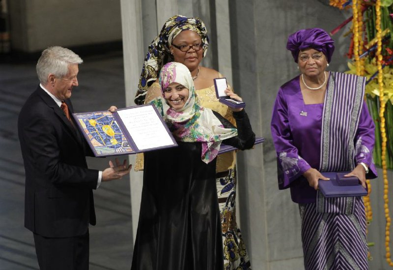 Nobel Peace Prize winners Tawakkol Karman of Yemen, center, Liberian peace activist Leymah Gbowee, behind,  and Liberian president Ellen Johnson-Sirleaf, right, receive their diplomas and medals from  Nobel  Committee Chairman Thorbjoern Jagland, left, at City Hall in in Oslo, Norway Saturday Dec. 10, 2011. The peace prize committee awarded the prize to Karman,  Johnson-Sirleaf and Gbowee for championing women's rights in regions where oppression is common and helping women participate in peace-building., (AP Photo/John McConnico)