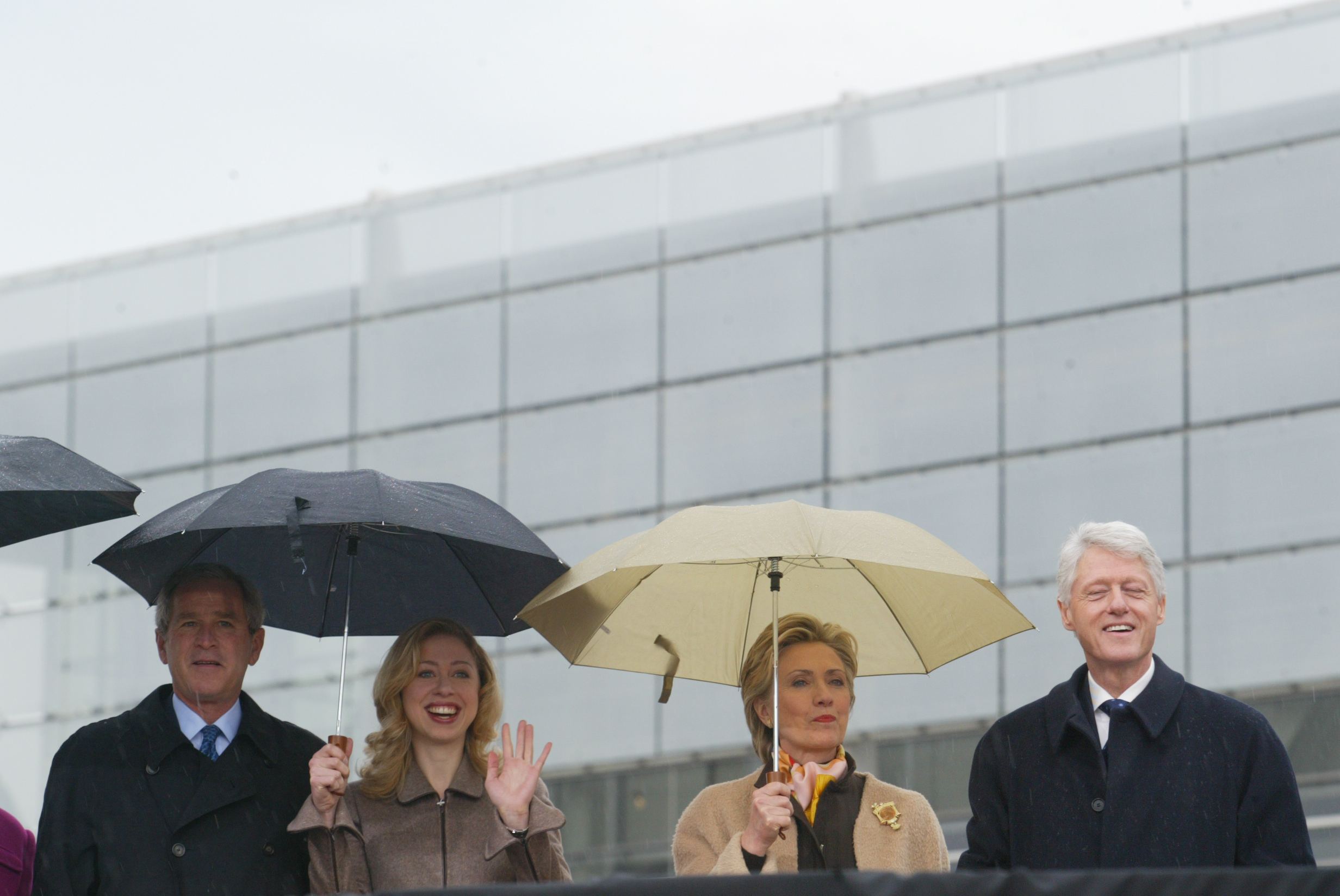 2004 | Chelsea Clinton waves to someone in the crowd while standing with President George W. Bush, former Presidnet Bill Clinton and Sen. Hillary Clinton at the Clinton Library Dedication.