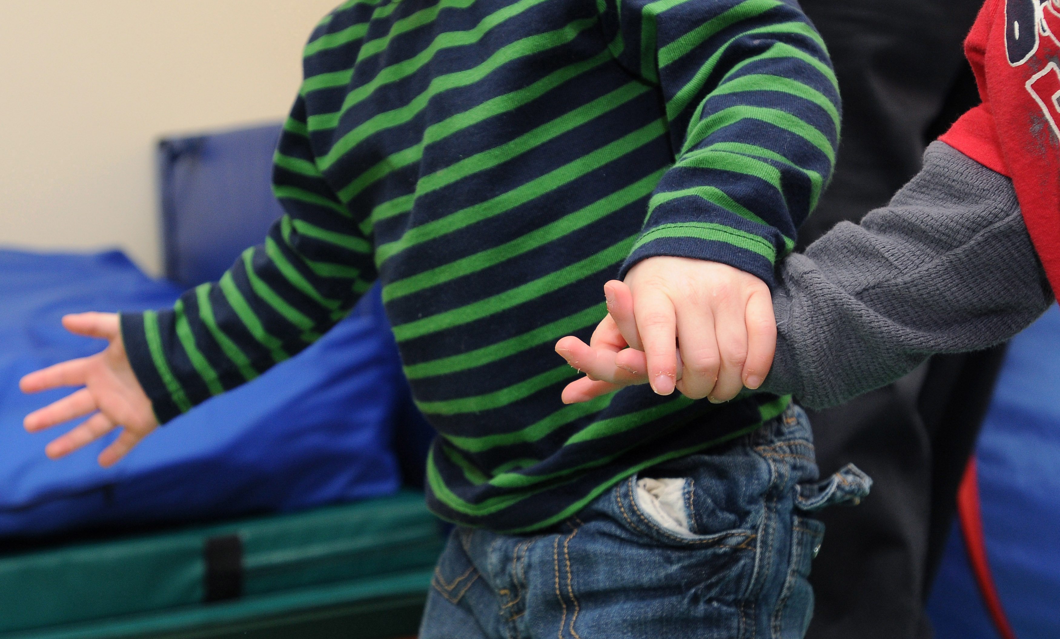 Twin brothers hold hands Wednesday, Nov. 30, 2011, in the gross motor skills room at the Northwest Arkansas Children's Shelter. The Northwest Arkansas Children's Shelter is a temporary home, up to 45 day, for boys ages birth to 12 years old and girls ages birth to 17 years old who have been removed from their home because of neglect, physical abuse, or sexual abuse.
