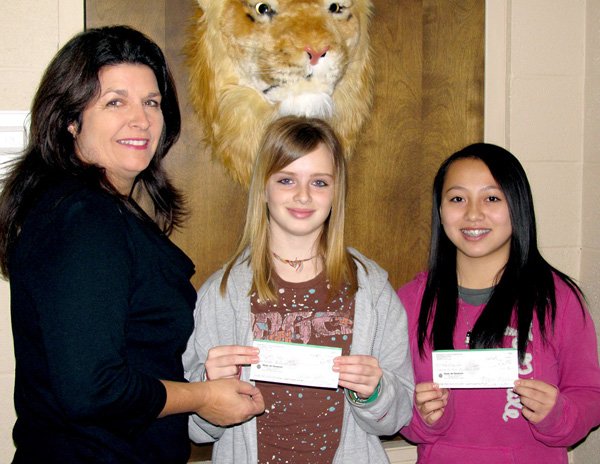 Austina Lee, right, won first place in the Bella Vista VFW Democracy essay contest in competition with students from Bentonville/Gravette middle schools. Third place was won by Tiffany May. Presenting checks to the winners was Brenda Yates, representing the Kiwanis Club which sponsors the Middle School Builder's Club.