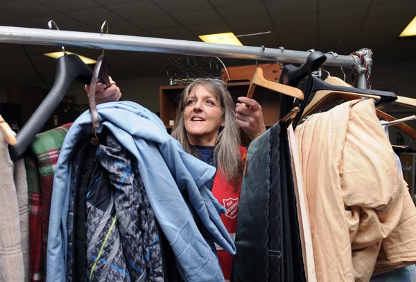Glenda Nunn moves new donations off a temporary rack Dec. 20 and integrates the items with current merchandise at the Salvation Army Thrift Store in Fayetteville. Items are priced based on the condition the items are in when received, but are always lower than the price the item was purchased at new. The thrift store accepts donations of clothes, electronics, furniture, household items, books, blankets, movies and more, which are then sold to the public, one of the major sources of funding for the Salvation Army, or used as a bank of items in need for people with valid vouchers.
