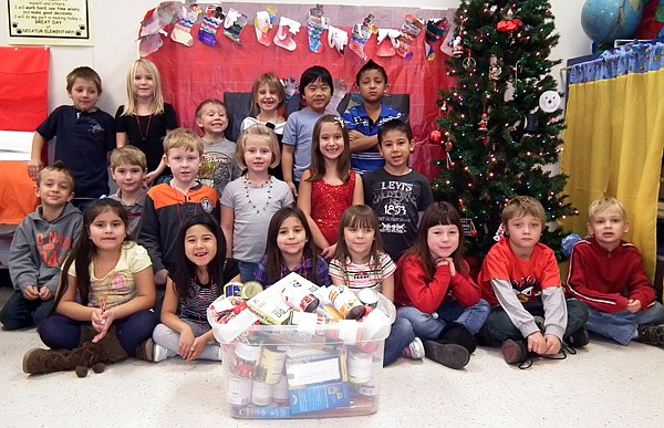 Janet Barkley’s first-grade class posed with food they earned with home chores.