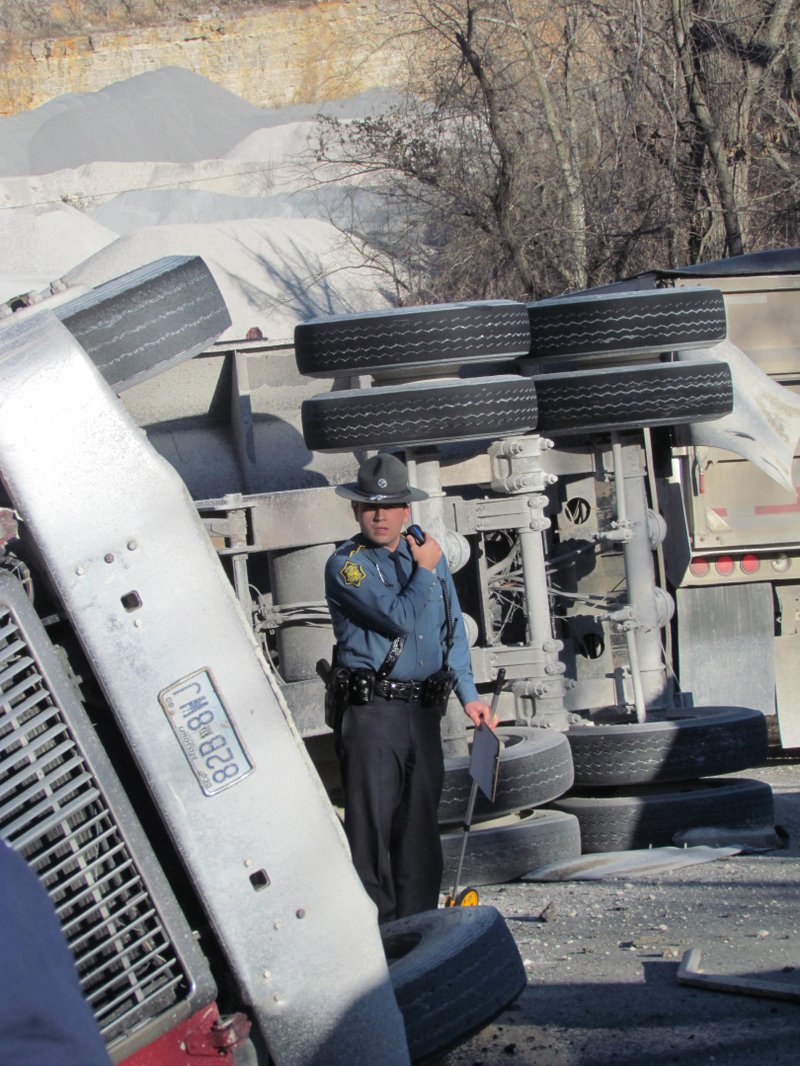 A trooper examines an overturned gravel truck Wednesday.