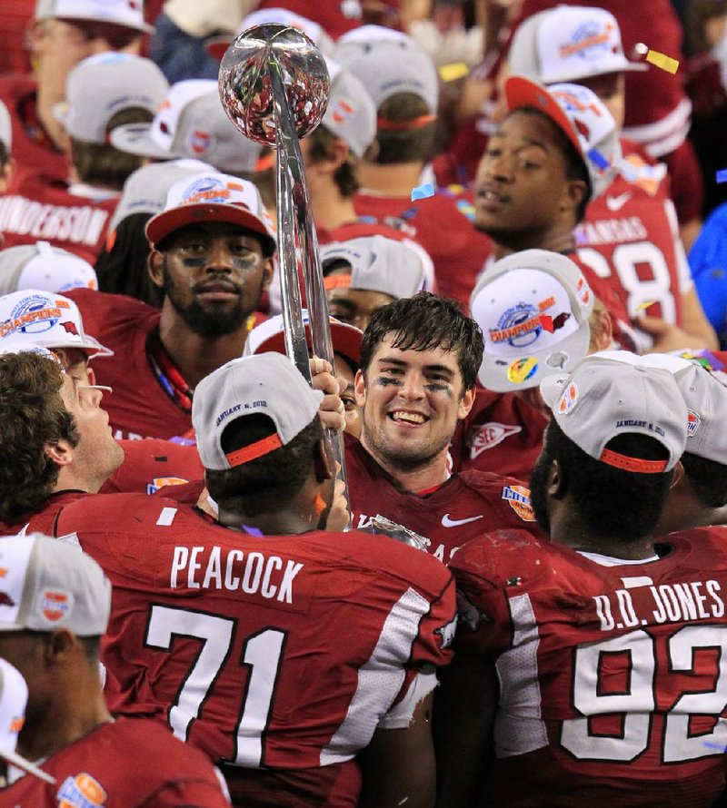 Arkansas defensive MVP, Jake Bequette holds up the Cotton Bowl trophy with team mates after defeating Kansas State 29-16 at Cowboys Stadium. 