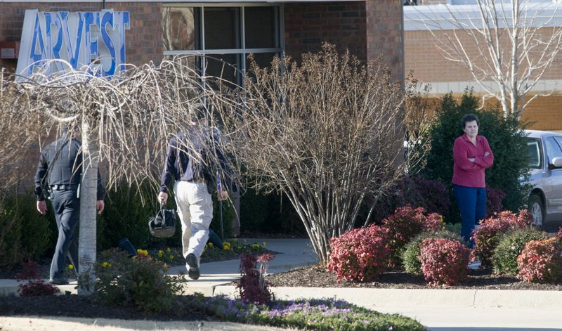Betty Davis stands outside of the Arvest Bank on  in Fayetteville, Monday Jan. 9, 2012, as police officers approach her. The police and Bomb Squad were called out to the bank after Davis reported she had been kidnapped and a bomb was strapped to her ankle. 