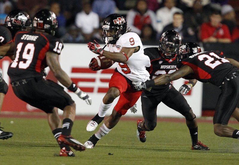 Arkansas State wide receiver Dwayne Frampton (9) tries to get past Northern Illinois' Dechane Durante (21) and Demetrius Stone (19) after a catch in the first half of the GoDaddy.com Bowl NCAA college football game on Sunday, Jan. 8, 2012, in Mobile, Ala.