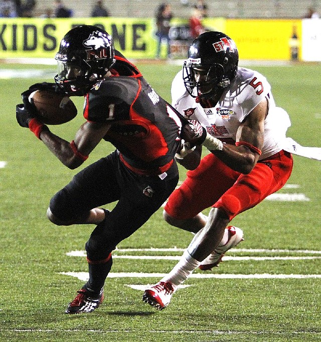 Northern Illinois wide receiver Martel Moore (1) tries to escape the tackle of Arkansas State defensive back Don Jones (5) after a reception in the second half of the Huskies’ 38-20 victory in the GoDaddy.com Bowl on Sunday night. 