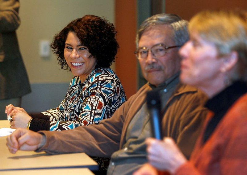 Arkansas Democrat-Gazette/JASON IVESTER --01/14/12--
Mireya (cq) Reith (from left) and Octavio (cq) Sanchez listen as Susie Hoeller (cq) speaks during a panel discussion on immigration policy inside the Fayetteville Public Library on Saturday, Jan. 14, 2012.