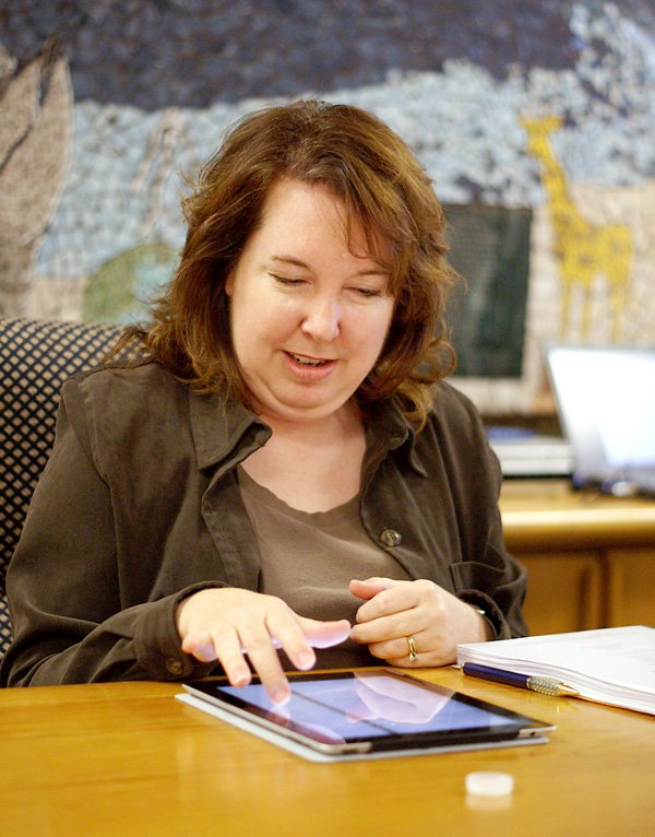 Gentry School Board member Dani Cypert looks at the board packet on an iPad during the Monday night school board meeting. The board was considering going paperless as a money-saving measure.
