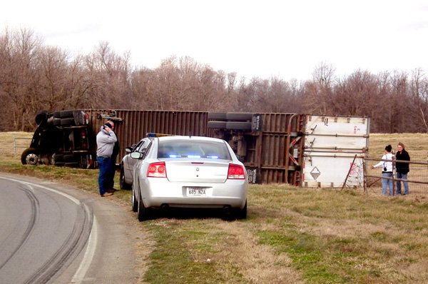 High winds were blamed for this tractor-trailer loss of control and overturn on Arkansas Highway 102 West in Decatur Monday morning. Police chief Terry Luker and Decatur firefighter Forest Tharp looked on while FNA employees surveyed the damage to their shipment of pressure washer motors.
