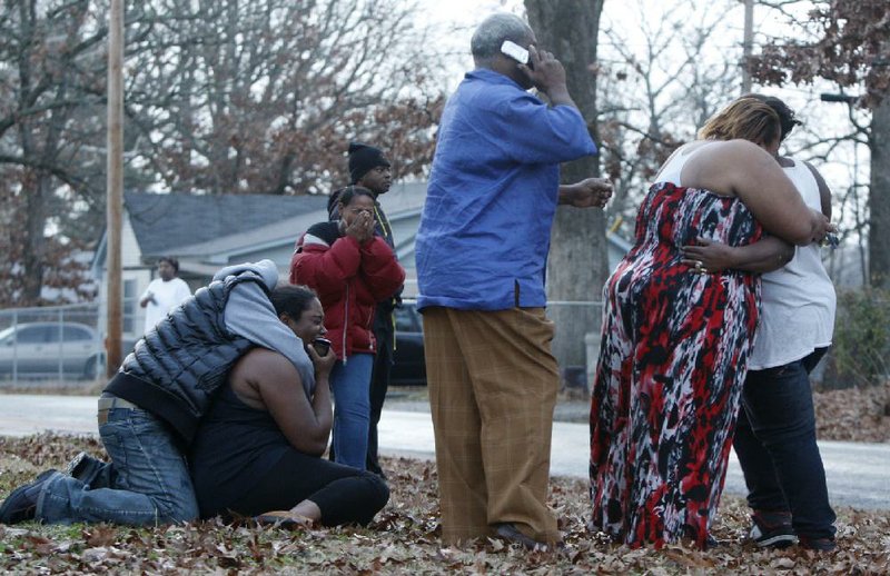 Family members react after police inform the group a relative was shot by police during a drug raid at 14th Street and South Tyler in Little Rock, January 17, 2012.