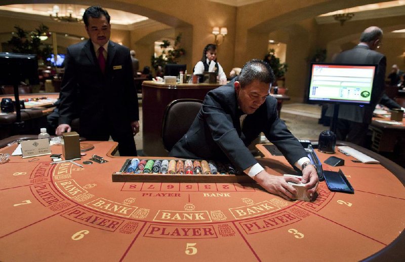 Baccarat dealer Ramiro Nepomuceno, right, shuffles cards as floor supervisor Sam Insyxiengmay looks on while preparing a table for play at the MGM Hotel and Casino, Wednesday, Jan. 25, 2012, in Las Vegas. There are generally more Asian gamblers in Vegas because of the Chinese New Year, and it means increased traffic at high limit baccarat tables. Though not widely known, baccarat is actually the most profitable table game for casinos which try to court Asian gamblers who tie luck and good fortune to the start of the Lunar Year. (AP Photo/Julie Jacobson)