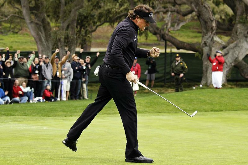 Phil Mickelson celebrates after making a long putt to save par on the 12th hole at Pebble Beach Golf Links during Sunday’s final round of the Pebble Beach National Pro-Am in Pebble Beach, Calif. Mickelson made up eight strokes over six holes and beat final round playing partner Tiger Woods by 11 shots on the day to claim his 40th career PGA Tour victory. 