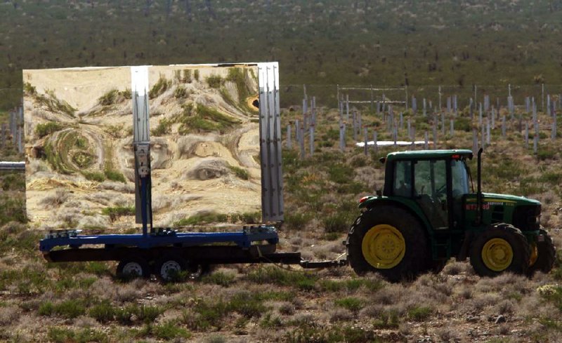 Mirrors that will be used to reflect the sun and generate power are hauled at BrightSource Energy’s Ivanpah solar generation plant site in the Mojave Desert last summer. 