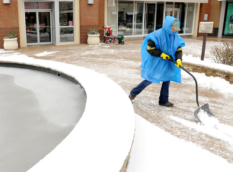 Sarah Dombrowski from All Around Landscaping Inc. shovels snow from storefronts and sidewalks on Monday morning in the Pinnacle Hills Promenade in Rogers, Ark. Monday, Feb. 13, 2012. The National Weather Service forecast calls for a high today near 47 degrees.