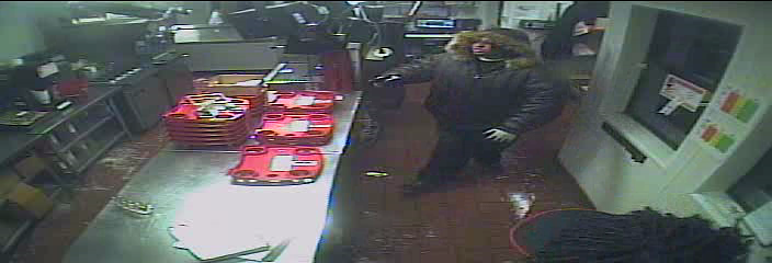 A still from security video shows a man holding up a Sonic eatery in England.