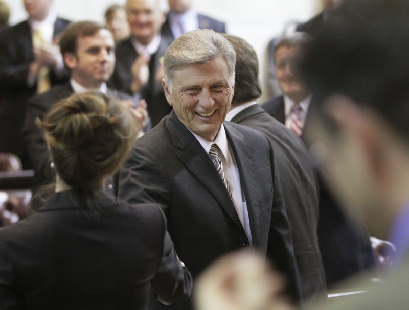 Arkansas Gov. Mike Beebe, center, is greeted by legislators as he walks through the House chamber at the Arkansas state Capitol in Little Rock, Ark., Monday, Feb. 13, 2012.