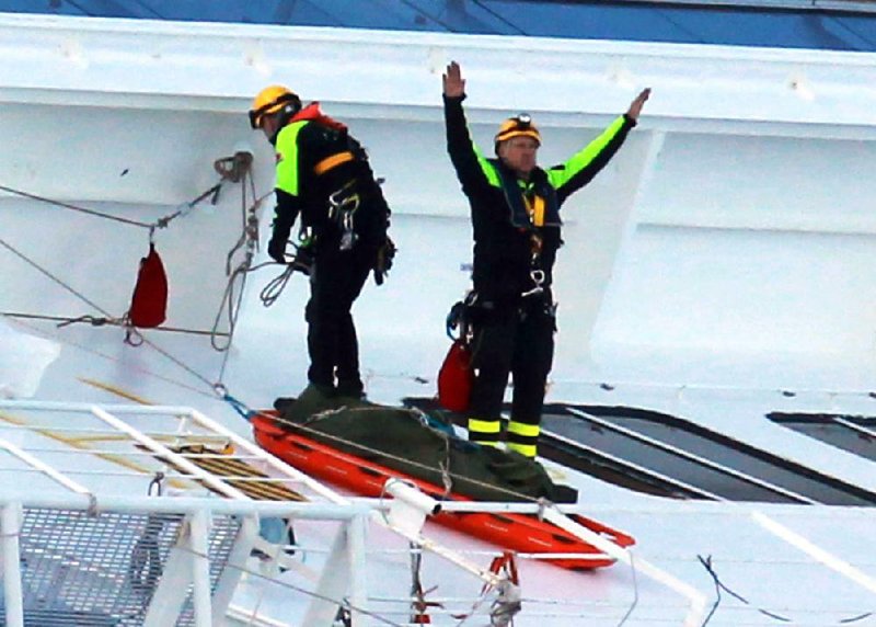 A fireman signals after recovering the body of one of the victims of the luxury ship Costa Concordia, Wednesday,  Feb. 22, 2012, that run aground off the Tuscany Isola del Giglio island on Jan. 13, 2012.  Divers searching the capsized cruise ship found eight bodies Wednesday on one of the passenger decks, including that of a missing 5-year-old Italian girl, authorities said. The bodies were being transferred to a hospital on the mainland for identification, a process which could take days. Before Wednesday's development, 15 people were listed as missing, but only one of them was a child, Dayana Arlotti. The 5-year-old girl was on the Mediterranean cruise with her father and his girlfriend. The girlfriend survived. The father was among the missing. (AP Photo/ Lapresse)