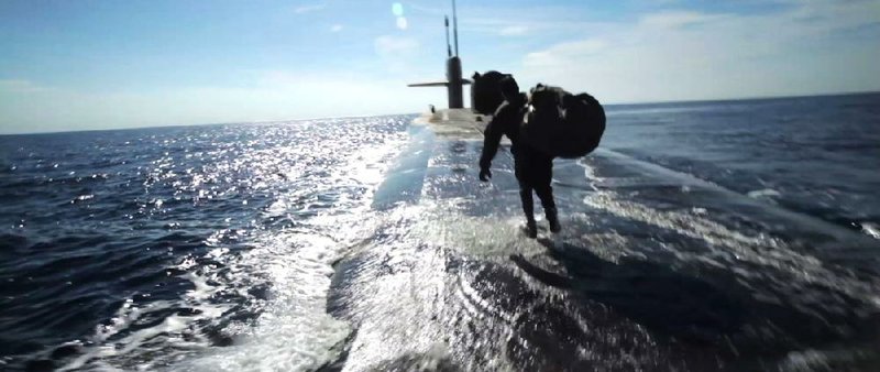 A Navy SEAL is dropped onto the hull of a submarine in Act of Valor, a fictional story that stars actual members of the elite special operations force. 