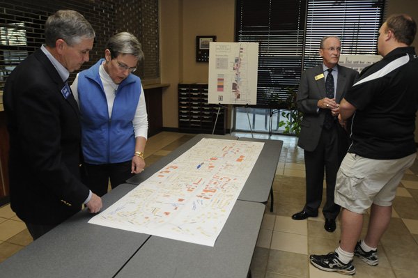 David Short, from left, president of Arvest Bank Benton County, and wife Deb Short look at a map of North Walton Boulevard on Thursday as Mayor Bob McCaslin talks with Don Carroll, owner of Batter Up in Bentonville, during a workshop.
