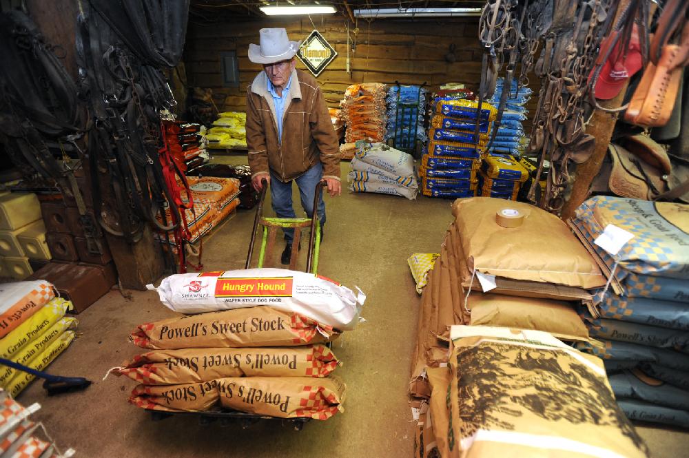 STAFF PHOTO ANDY SHUPE
Neil Mathews, 81, works Tuesday, Feb. 21, 2012, to fill an order for a customer inside the storeroom of the Mathews Horse and Feed Barn which he operates with his son in West Fork.