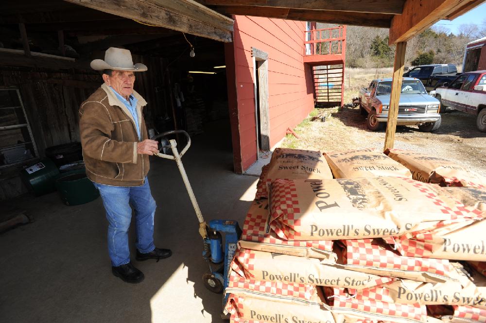 STAFF PHOTO ANDY SHUPE
Neil Mathews, 81, works Tuesday, Feb. 21, 2012, to load an order for a customer on the loading dock of the Mathews Horse and Feed Barn which he operates with his son in West Fork.