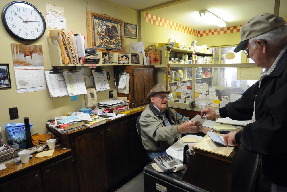 STAFF PHOTO MARC F. HENNING
John Mather, right, of Pea Ridge pays Fred McKinney for an order of feed for his miniature horses Wednesday, Feb. 22, 2012, at Webb's Feed and Seed Inc. in downtown Pea Ridge. McKinney, 90, began working at Webb's a week after he finished high school in 1940. McKinney said the store was established in 1936 by his father-in-law, Hugh Webb.