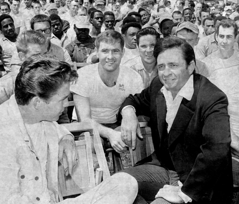 Johnny Cash talks with inmates during an appearance at Arkansas' Cummins Prison. 