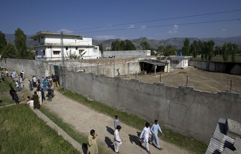 In this this May 3, 2011, file photo, media and local residents gather outside the compound where al-Qaida leader Osama bin Laden was caught and killed, in Abbottabad, Pakistan. 