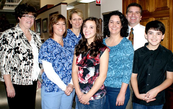 Pictured during the celebrating of his twenty years of dentistry business in Gravette, Dr. Kent Leonard and his wife Dorian and their children, Lauren and Cole, are shown on the right, along with the office staff, from the left, Roberta Yeagley, Kelley Hosteter and Lisa Pierce.
