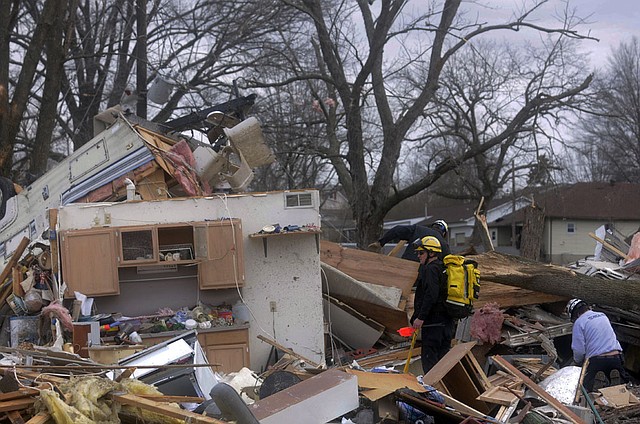 Emergency crews comb through some of the damage after a severe storm hit in the early morning hours on Wednesday, Feb. 29, 2012, in Harrisrbug, Ill.