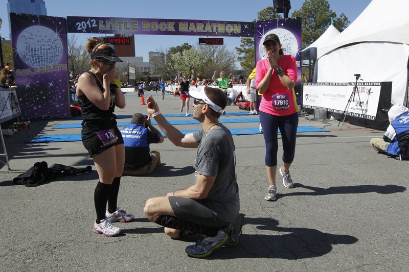 Jeff Martens proposes to Tracy Woodie just after the couple crossed the finish line of Sunday's Little Rock Marathon.