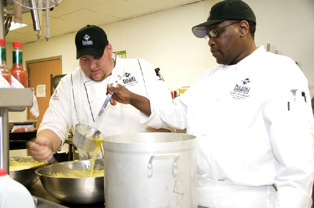 Arkansas Democrat-Gazette/CARY JENKINS
Jay McAfee and De'Mon Strickland prepare the sauce for the evenings entree.