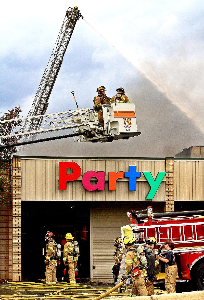 Little Rock firefighters attack a fire at Party City on Rodney Parham Rd. with aerial ladders Wednesday afternoon.