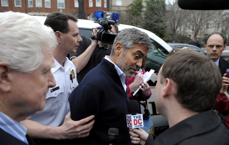 Actor George Clooney, center, and Rep. Jim Moran, D-Va., left, are led to a police vehicle after being arrested during a protest at the Sudan Embassy in Washington on Friday, March 16, 2012. 