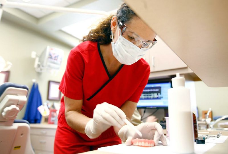 Dr. Brandi Roach works with a patient’s dentures on Friday at Fayetteville Family Dentistry. 