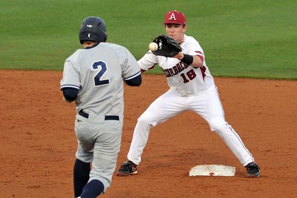 Arkansas shortstop Tim Carver (right) tags out Nevada baserunner Joe Kohan during the Razorbacks’ 10-2 victory Wednesday at Baum Stadium in Fayetteville. 