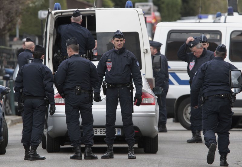 Police officers stand near a building in Toulouse, France, on Wednesday March 21, 2012, where a suspect in the shooting at the Ozar Hatorah Jewish school was barricaded in an apartment building. 