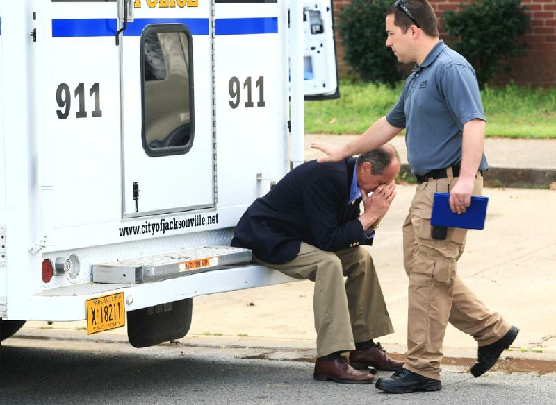 An investigator comforts Jacksonville Mayor Gary Fletcher outside Thursday morning’s fatal fire on South Simmons Drive. 