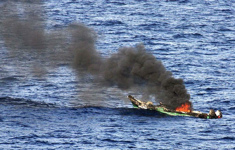 A suspected pirate’s skiff burns after being blasted by a U.S. Navy ship in this 2010 photo released by the Navy. 