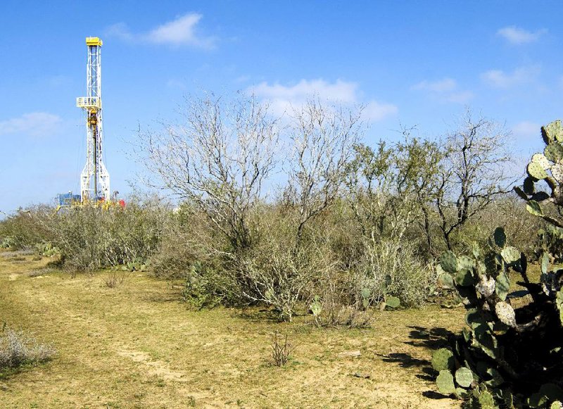 A Petrohawk Energy Corp. drilling rig stands amid scrub and cactus in the Eagle Ford Shale in southern Texas in this July photo from Petrohawk. 