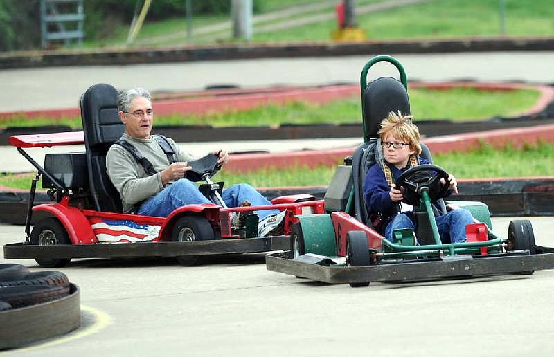 Charlie Rossetti from West Fork follows his grandson Campbell Osier, 8, from Greenland, around a corner as they race go carts Friday morning at Lokomotion Family fun Center in Fayetteville.