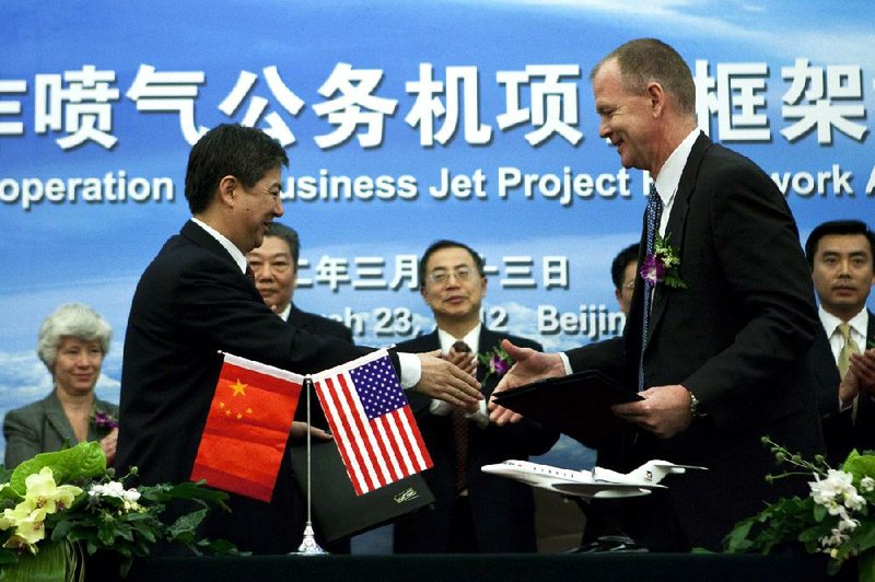 Scott Donnelly, chairman and chief executive of Cessna Aircraft parent Textron (right), greets Xu Zhanbin, vice general manager of state-owned Aviation Industry Corp. of China, during a signing ceremony Friday in Beijing. 
