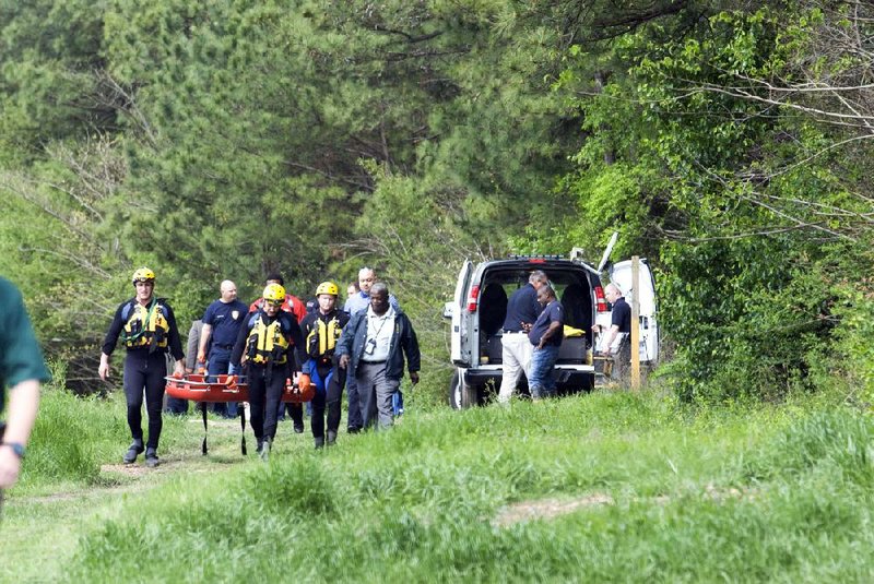 Members of the Little Rock Fire Department leave Rock Creek on Friday after they retrieved the body of a woman who was washed away from Wednesday's heavy rainfall.  The woman was found on the east bank of Rock Creek near the intersection of 36th and Col. Glenn Road.
